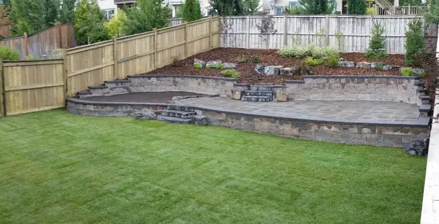 Terraced backyard with block retaining walls, steps and lawn
